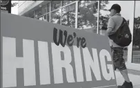  ?? OLIVIER DOULIERY/AFP VIA GETTY IMAGES ?? A man walks past a “now hiring” sign posted outside of a restaurant in Arlington, Va. on June 3.