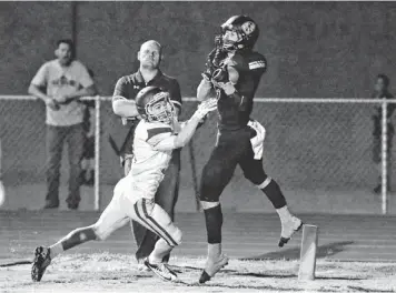  ?? DAVID KADLUBOWSK­I/AZCENTRAL SPORTS ?? Saguaro's J.T. Nettleton (right) makes a catch against Queen Creek's Bailey Rogers on Oct. 4 in Scottsdale. Saguaro players and coaches have dedicated the season to late equipment man Mike “Tug” Garcia and will wear some green to honor Garcia for...