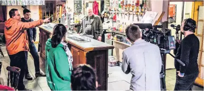  ??  ?? The filming of Canaries in the Tafarn y Twrch pub in Lower Cwmtwrch with actor Robert Pugh behind the bar. Craig Russell is pictured second left.