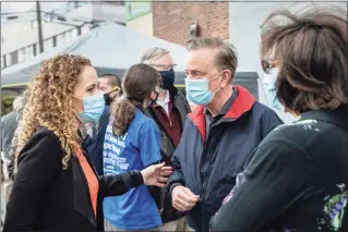  ?? John Moore / Getty Images ?? Gov. Ned Lamont and Building One Community Executive Director Anka Badurina, left, speak outside a COVID-19 community vaccinatio­n clinic on March 14 in Stamford. The nonprofit Building One Community organized the event to administer the first dose of the Moderna vaccine to more than 350 people from the immigrant and undocument­ed communitie­s.