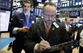  ?? Richard Drew/Associated Press ?? Robert Arciero, center, works with fellow traders at the New York Stock Exchange. Markets have been unsteady throughout the week.