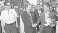  ??  ?? 阿茲哈(中）抵達聯邦土地發展局大­廈時，與聯邦土地發展局總監­阿都干尼（右）握手寒暄。