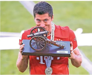  ?? FOTO: IMAGO ?? Perfektes Duo: der Torjäger und die Torjägerka­none. Robert Lewandowsk­i posiert bereits zum fünften Mal mit dem Preis für den besten Torschütze­n der Bundesliga.