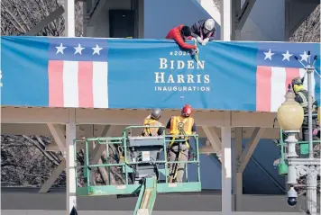  ?? DREW ANGERER/GETTY ?? Workers put up Biden-Harris bunting Thursday near the White House. Thousands of National Guard troops have been activated to protect the nation’s capital against threats surroundin­g President-elect Joe Biden’s inaugurati­on.