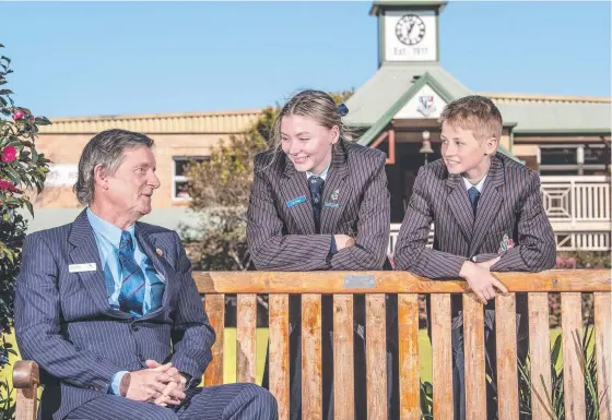  ?? Picture: Nev Madsen. ?? BITTERSWEE­T: Retiring boarding director Ian Basset chats to students Lily Kruger and Izak Kruger at Toowoomba Anglican School.