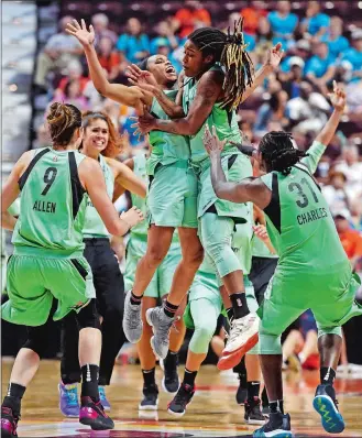  ?? SEAN D. ELLIOT/THE DAY ?? New York Liberty guard Shavonte Zellous, leaping, right, celebrates with her teammates after hitting a 3-pointer at the buzzer to defeat the Connecticu­t Sun in WNBA Eastern Conference action Wednesday at Mohegan Sun Arena. The Liberty emerged with the 79-76 win.
