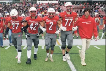  ?? Ned Gerard / Hearst Connecticu­t Media ?? Patrick Rutledge, right, Ryan Rutledge’s twin brother, walks with members of the Pomperaug High School football team as they approach for the coin toss before Friday night’s game against Bunnell High School in Southbury. Ryan Rutledge, who have been a starting senior on the Pomperaug football team, was killed in an automobile accident in April.