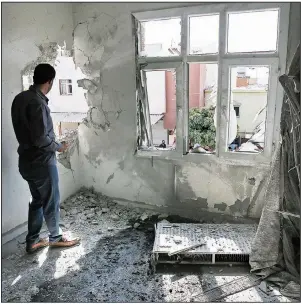  ?? AP/LEFTERIS PITARAKIS ?? A person in Sanliurfa, Turkey, inspects a building damaged Sunday by a mortar round fired from Syria. More photos are available at arkansason­line.com/1014syria/