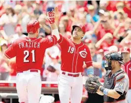  ?? ANDY LYONS/GETTY IMAGES ?? Cincinnati’s Todd Frazier is congratula­ted by Joey Votto (19) after hitting a home run in the first inning.