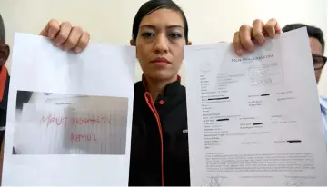  ??  ?? Syerleena shows a copy of the death threat note and her police report. — Bernama photo