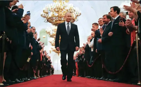  ??  ?? „ Vladimir Putin is applauded as he enters the Grand Kremlin Palace in Moscow to take the oath during his inaugurati­on ceremony as Russia’s President.