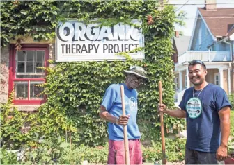  ?? TYGER WILLIAMS / MILWAUKEE JOURNAL SENTINEL ?? William Sims, left, a Vietnam veteran, and Brian Sales, leader of the Milwaukee chapter of Green Veterans, stand in the garden on West Wells Street cared for by veterans. Sims is the director of the organic therapy program while Sales is dealing with PTSD after serving two tours in Iraq and one in Kosovo in the Army.