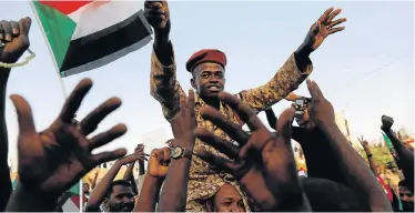  ?? Picture: REUTERS/UMIT BEKTAS ?? NOT BACKING DOWN: A Sudanese soldier sits on the shoulders of a demonstrat­or, cheering with the crowd outside the defence ministry in Khartoum