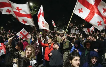  ?? ?? Demonstrat­ors waving Georgian national flags gather in front of the Parliament building during an opposition protest against "the Russian law" in the center of Tbilisi, Georgia, early Monday, May 13, 2024. Daily protests are continuing against a proposed bill that critics say would stifle media freedom and obstruct the country's bid to join the European Union. (AP Photo/Zurab Tsertsvadz­e)