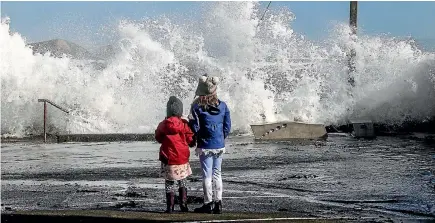  ?? PHOTO: FAIRFAX NZ ?? Children watch the rough seas at Plimmerton, Porirua. The large waves followed a night of wild weather that saw highways washed out, trees toppled and trampoline­s sent flying across the Wellington region. Parts of the Porirua coast were hammered by the...