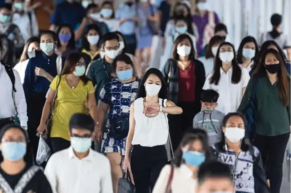  ??  ?? Search for vaccine: Office workers wearing face masks to help curb the spread of the coronaviru­s heading to work in Bangkok. Thailand recently announced it expects to have a vaccine for Covid-19 ready by next year after finding positive trial results in mice.