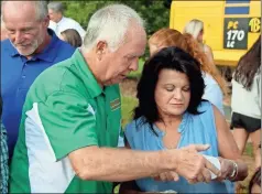  ?? Jeremy stewart ?? Tommy Sanders (left) gives former Pizza Farm employee Jan Gore a jar of the restaurant’s original salad dressing during the groundbrea­king for the new Pizza Farm on Monday, Aug. 2.