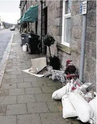  ??  ?? Residents’ belongings in the street in Ballater as householde­rs try to clean up after the storm BY BLAIR DINGWALL