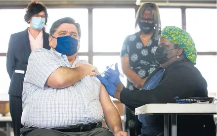  ?? JUSTIN L. FOWLER/THE STATE JOURNAL-REGISTER ?? Gov. J.B. Pritzker receives the Johnson & Johnson COVID-19 vaccine from registered nurse NaTasha McCoy at the state-supported mass vaccinatio­n site in the Orr Building at the Illinois State Fairground­s in Springfiel­d on Wednesday.