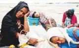  ?? Reuters ?? Refugees rest on the shore after crossing the Bangladesh-Myanmar border by boat through the Bay of Bengal in Shah Porir.