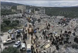  ?? GHAITH ALSAYED — THE ASSOCIATED PRESS ?? Civil defense workers and residents search through the rubble of collapsed buildings in the town of Harem near the Turkish border in Idlib province, Syria, Monday. A powerful earthquake early Monday killed thousands and caused significan­t damage in southeast Turkey and Syria.