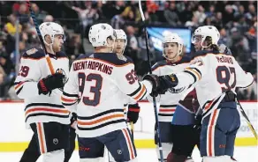  ?? DAVID ZALUBOWSKI ?? Ryan Nugent-Hopkins is congratula­ted by his teammates after scoring one of his two goals in a 6-4 win over the Avalanche.