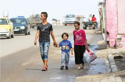  ??  ?? Youngsters walk to the main beach road of the Shati refugee camp in Gaza City on Monday. (AP)