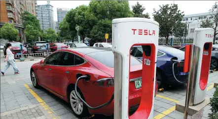  ?? WANG QIMING / FOR CHINA DAILY ?? Tesla sedans charge at a parking lot in Changzhou, Jiangsu province.