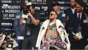  ??  ?? Conor McGregor tosses dollar bills in the air during a press conference in 2017