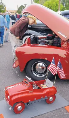  ?? GREG SORBER/JOURNAL ?? Daniel Goodman of Albuquerqu­e looks at the engine of a 1952 Chevrolet 3100 five-window pickup at the 35th Annual New Mexico Council of Car Clubs Classic Auto Show at the Albuquerqu­e Museum. A Chevrolet pedal car sits beside the truck.