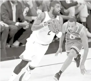  ?? AP ?? Acción. Kyrie Irving, de los Cavaliers, maneja el balón frente a la defensa de Avery Bradley, de los Celtics, en acción del partido de anoche en los playoffs de la NBA.