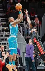  ?? Nell Redmond / Associated Press ?? Charlotte’s Terry Rozier, left, shoots over Miami’s Victor Oladipo in the Hornets’ 122-117 win. Rozier scored 31 points