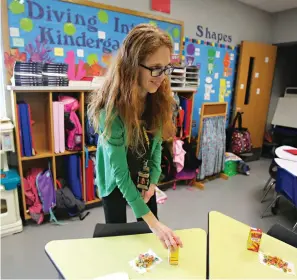  ?? Jerry Larson/Waco Tribune Herald, via AP ?? ■ Michelle Porter prepares her kindergart­en classroom Feb. 28 in McGregor, Texas. Porter was a senior at Columbine High School when two students killed 13 others in 1999. Now into her second year as a teacher at McGregor Primary School, when Porter...