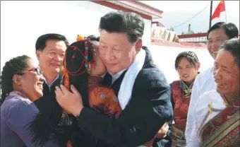  ?? PANG XINGLEI / XINHUA ?? President Xi Jinping hugs 5-year-old Tseyang Lhamo while visiting Tibetan ethnic villagers in Qinghai province on Monday.