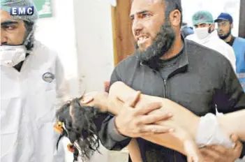  ?? FOTO: AP ?? ►► Un hombre traslada a una niña en un hospital tras el ataque de ayer.
