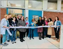  ?? NORWOOD PUBLIC LIBRARY ?? Norwood Public Library Director Eileen Baker, surrounded by local officials, library staff and patrons, cuts the ribbon last week on the new ADA compliant door to the library.