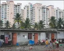  ?? ?? Children play July 20 in a poor neighborho­od next to an upscale residentia­l apartment building in Bengaluru, India.