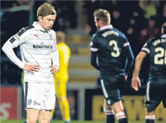  ?? Picture: SNS. ?? Dundee striker Craig Wighton cuts a dejected figure at full-time as County players celebrate their last-gasp victory.