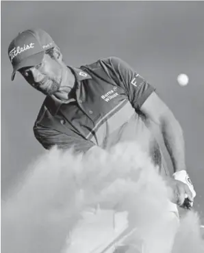  ?? Richard Heathcote, Getty Images ?? Webb Simpson plays a shot from a bunker on the 18th hole during the third round of The Players Championsh­ip on the Stadium Course at TPC Sawgrass on Saturday. His 4-under 68 gave him a seven-shot lead going into Sunday.