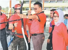  ??  ?? Abdul Karim tries out archery as Fatimah (right) looks on.