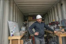  ??  ?? Chris Radwanski, data center supervisor for Stronghold Digital Mining, works in a shipping container used to repair Bitcoin-mining machines.