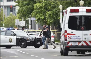  ?? AP PHOTO ?? Fresno police members walk near a shooting scene Tuesday in Fresno.