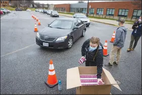  ?? JULIA RENDLEMAN / THE NEW YORK TIMES ?? At-home COVID-19 testing kits are handed out Sunday at Martin Luther King Jr. Middle School in Richmond, Va. A surge in COVID cases, brought on by the fast-spreading omicron variant, along with labor shortages, has exposed the jerry-built measures that have kept schools open until now. Students’ return from the holiday break, however, is testing those measures.