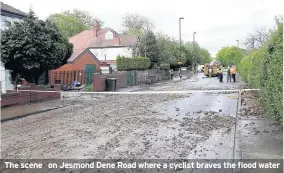  ??  ?? The scene on Jesmond Dene Road where a cyclist braves the flood water