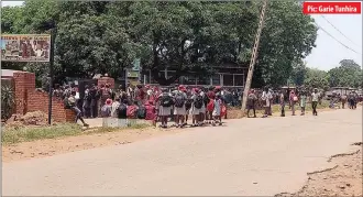  ??  ?? Pic: Garie Tunhira
Dzivaresek­wa 1 High School pupils in Harare mill outside the school yard as the last batch of students joined others yesterday under the schools’ three-phased reopening programme