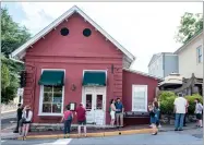  ?? AP PHOTO BY DANIEL LIN ?? In this June 23, file photo, passersby gather to take photos in front of the Red Hen Restaurant in Lexington, Va. The restaurant has become internatio­nally famous since ousting Sarah Huckabee Sanders over the weekend.