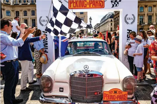  ??  ?? Above: The finishing arch was an Arc de Triomphe for Gary and Ken Below: Justifiabl­y proud of the medal they won for being the car and team that most respected the ‘spirit of the event’