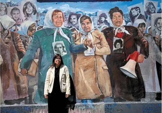  ?? —AP ?? Painful roots: poblete posing for a photo in frontofa mural depicting the Mothers of plaza de Mayo group, at the former Navy School of Mechanics, known as Esma, now a human rights museum, in Buenos aires, argentina.