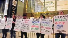  ?? INTERNATIO­NALIST GROUP/ASSOCIATED PRESS ?? Internatio­nalist protesters stand outside Trump Tower late Friday in New York City. The U.S., France and Britain launched military strikes Friday, targeting chemical weapons production and storage facilities.