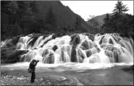  ?? HUA XIAOFENG / FOR CHINA DAILY ?? A photograph­er takes a picture of Shuanglong­hai Waterfall, a new scenic spot formed after the earthquake in Jiuzhaigou, Sichuan province, in November.